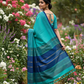 Handwoven turquoise cotton saree back view in garden