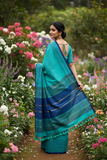 Handwoven turquoise cotton saree back view in garden